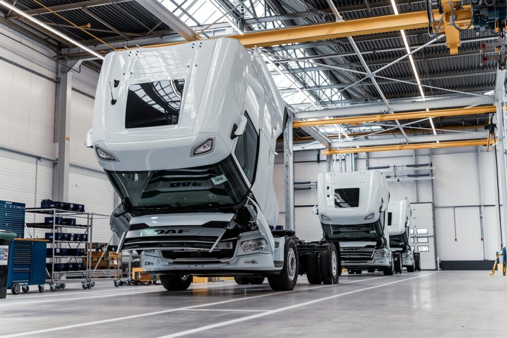 DAF trucks in een rij achter elkaar in een fabriekshal