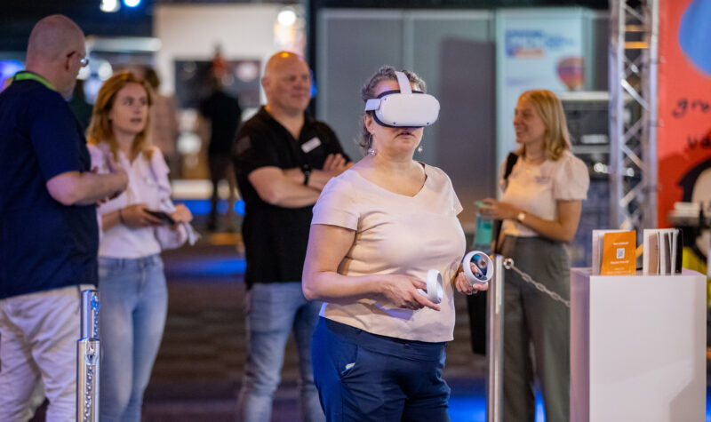 Vrouw met een VR-bril op bij een beursstand