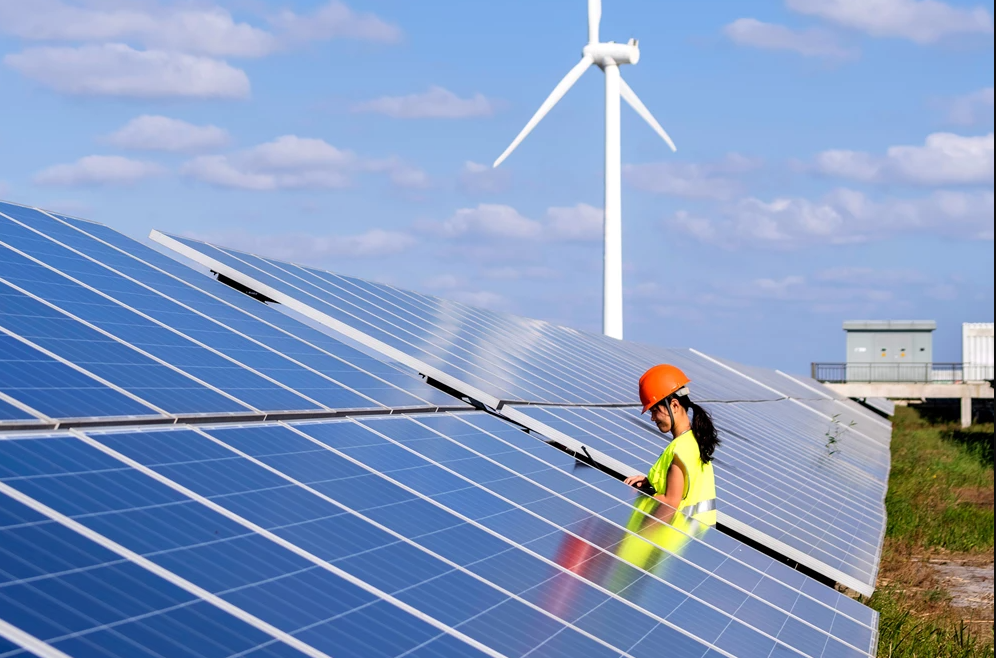 Vrouw met helm op een veld vol zonnepanelen